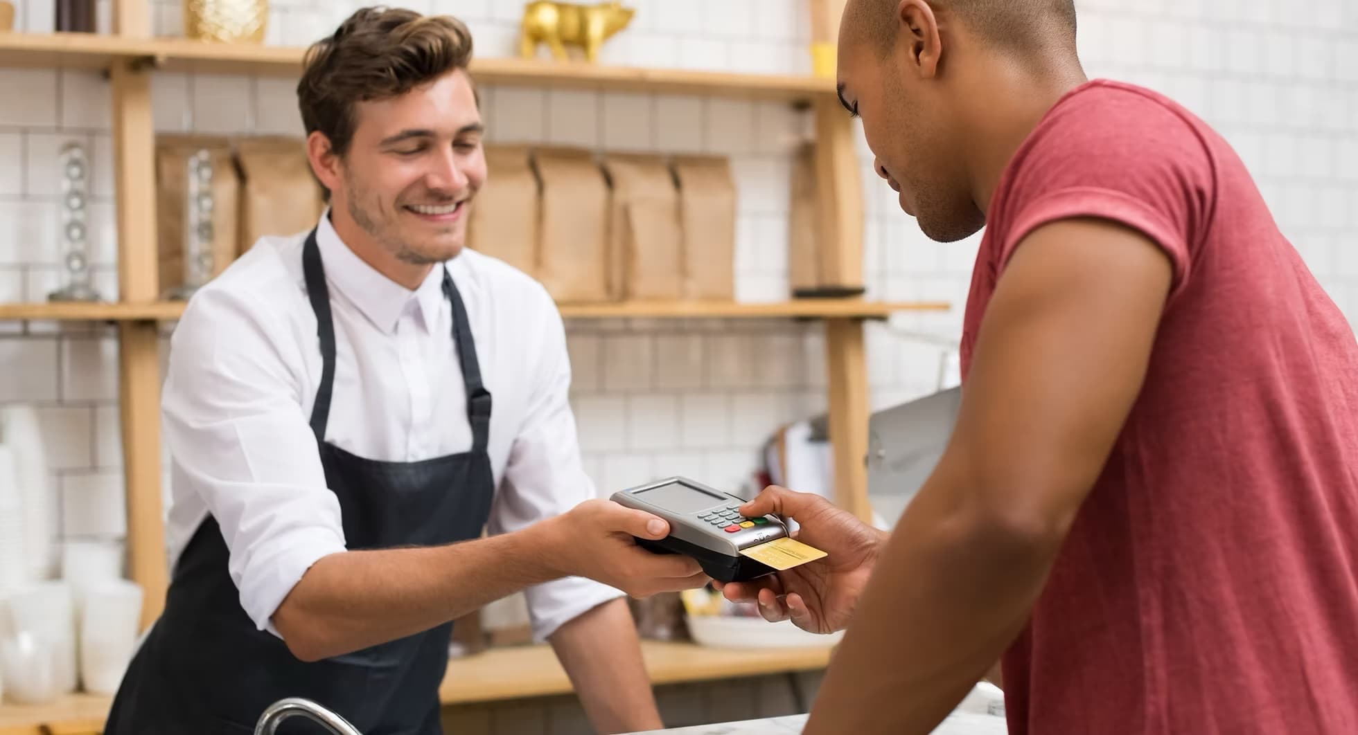 Shop owner handing a customer a card payment terminal